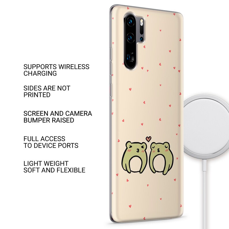 Op de afbeelding: Een transparante telefoonhoes met een lichtbeige achtergrond en een patroon van kleine rode hartjes. Twee groene kikkers bevinden zich in het midden van de hoes en kijken elkaar aan. De kikker links heeft een klein hartje boven zijn kop. De hoes ondersteunt draadloos opladen.