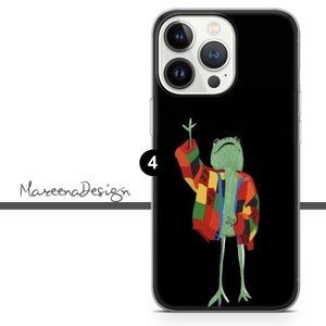 Op de afbeelding: Een zwarte telefoonhoes met een groene kikker die een kleurrijke, gepatroneerde trui draagt. De kikker houdt een hand omhoog en heeft een verraste uitdrukking op zijn gezicht.
