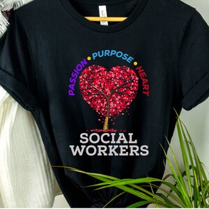 May include: Black t-shirt with a red heart-shaped tree with the words "Passion", "Purpose", "Heart", and "Social Workers" printed on it.