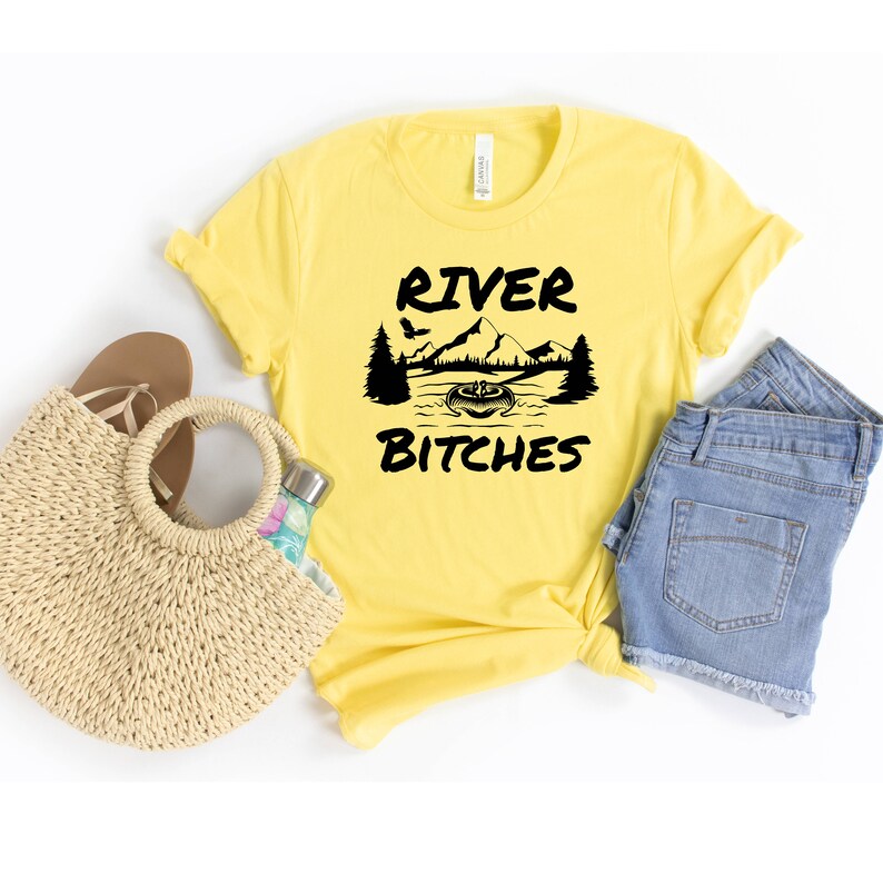 May include: Yellow t-shirt with a black graphic of a mountain scene and the text "River Bitches".