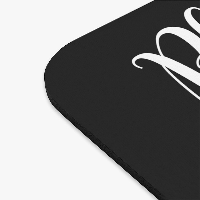 May include: Black mouse pad with white cursive text that reads "Believe".