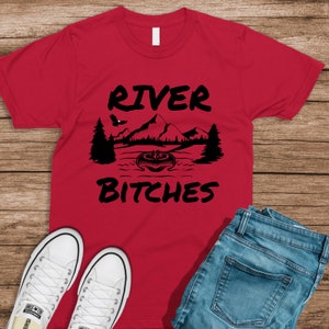 May include: Red t-shirt with a black graphic of a mountain scene and the text "River Bitches".