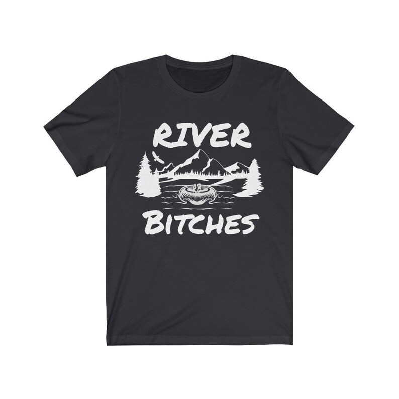 Pu&ograve; includere: T-shirt nero con un design grafico bianco di una scena di montagna con il testo "River Bitches".