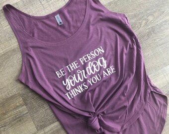 May include: Purple tank top with the text "Be the person your dog thinks you are" in white.