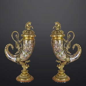 Könnte beinhalten: Ein Paar verzierte goldene und weiße Dekorhörner mit komplizierten Details. Die Hörner sind aus Keramik und haben ein Blumenmuster. Die Hörner sind auf einem goldenen Sockel montiert.
