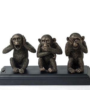 May include: Three bronze monkey figurines, each with a different gesture: one covering its ears, one covering its mouth, and one covering its eyes. The monkeys are sitting on a black base.