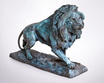 May include: A bronze lion sculpture with a verdigris finish. The lion is depicted in a walking pose, with its head turned to the side. The sculpture is mounted on a rectangular base.