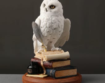 Estatua de búho nival con texto escrito sobre una pila de libros