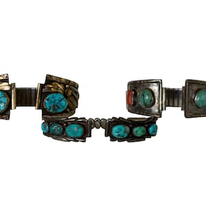 Op de afbeelding: Drie zilveren en turquoise horlogebandjes. De bovenste twee bandjes hebben een scharnierontwerp en het onderste bandje heeft een rij turquoise stenen.
