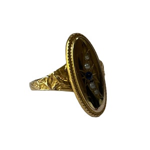 Peut inclure: Une bague en or avec une b&eacute;li&egrave;re ovale sertie d'un motif d'&eacute;toile avec des pierres bleues et blanches.
