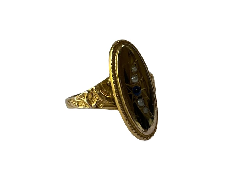 Peut inclure: Une bague en or avec une b&eacute;li&egrave;re ovale sertie d'un motif d'&eacute;toile avec des pierres bleues et blanches.