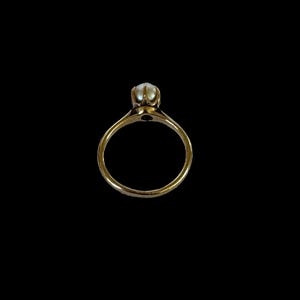 May include: A gold ring with a single pearl set in the center.