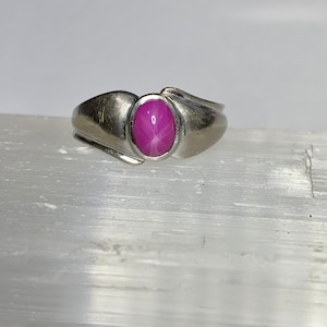 Op de afbeelding: Een zilveren ring met een roze ster-saffier edelsteen.