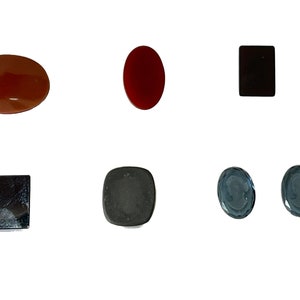 Op de afbeelding: Assortiment van zes ovale en vierkante cabochon edelstenen. De edelstenen zijn in tinten rood, bruin, zwart en blauw.
