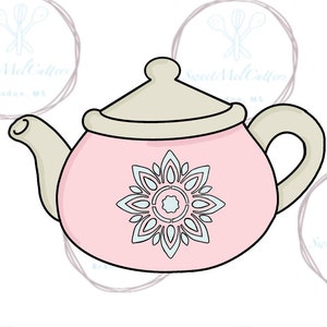 May include: A pink teapot cookie cutter with a white lid and a blue and white mandala design.