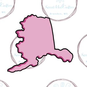 May include: A pink and black cookie cutter in the shape of the state of Alaska.