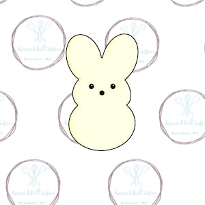 May include: A light yellow bunny-shaped cookie cutter with black eyes and a black mouth. The cookie cutter is outlined in black. The background has a repeating pattern of a logo with the text "Sweet Mel Cutters" and "Brandon, MS".
