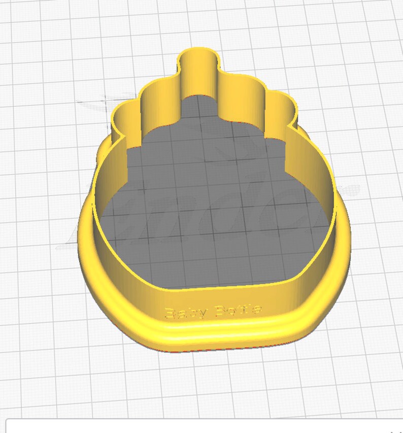 May include: Yellow plastic cookie cutter shaped like a baby bottle. The cutter has a rounded top with a raised rim and a flat bottom with the words "Baby Bottle" inscribed.