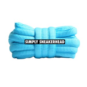 Può includere: Un fascio di lacci delle scarpe azzurri, ben avvolti e fissati. I lacci sono di un colore vivace e uniforme, con un aspetto strutturato e tessuto. Il testo "SIMPLY SNEAKERHEAD" è visualizzato in un rettangolo bianco sui lacci.