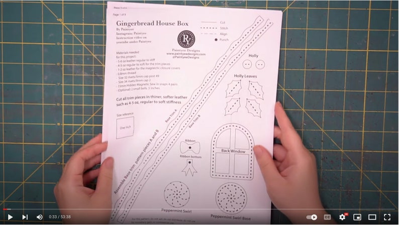 May include: A printed paper pattern for a Gingerbread House Box, featuring detailed line drawings of various components like holly leaves, a back window, and peppermint swirls. The pattern includes text and a size reference of one inch.