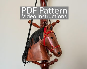 May include: A brown leather horse head bag with black fringe and a red bridle, hanging on a wooden coat rack. The bag has gold-colored hardware and the text "PDF Pattern Video Instructions" in a gray box.