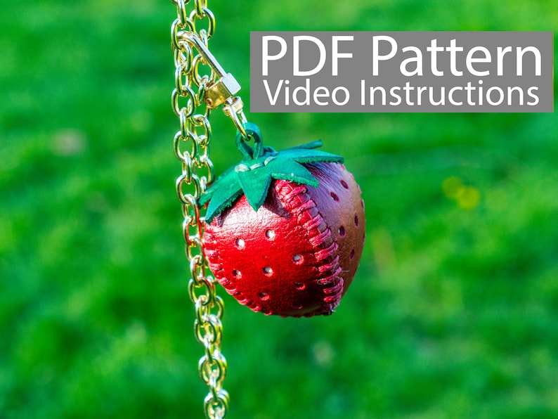 May include: A red leather strawberry keychain with green felt leaves, hanging from a gold chain. The image includes the text "PDF Pattern Video Instructions".