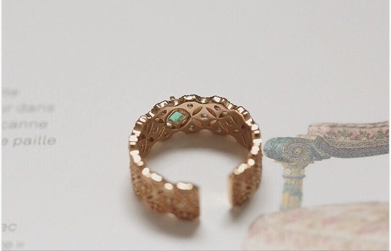 May include: Gold ring with a delicate, intricate design. The ring features a small turquoise gemstone in the center.