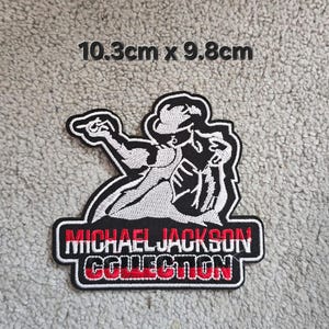 May include: An embroidered patch, 10.3cm x 9.8cm, with a black and white design of a performer. The patch has the text "MICHAEL JACKSON COLLECTION" in red and white.