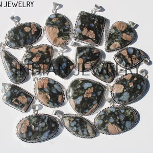 Peut inclure: Un ensemble de 15 pendentifs en argent avec des pierres de différentes couleurs, bleu, vert et rose, tachetées.
