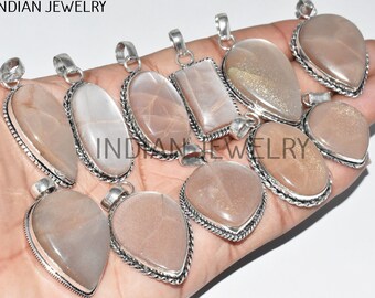 Puede incluir: Una colección de diez colgantes de plata con piedras preciosas de piedra de sol. Los colgantes son de diferentes formas y tamaños, y tienen intrincados diseños de plata. La piedra de sol es de color marrón claro con un efecto brillante.