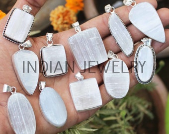 May include: A collection of ten white selenite crystal pendants with silver settings. The pendants are in various shapes, including square, oval, and teardrop. The pendants are displayed on a hand.