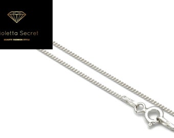 May include: A silver curb chain necklace with a lobster clasp. The necklace is displayed on a white background. The upper left corner features a black rectangle with the text "Violetta Secret BEAUTY FASHION STYLE" and a diamond logo.