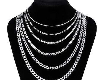 May include: A set of six silver chain necklaces of varying widths, displayed on a black velvet stand. The chains are all made of a classic curb link style.