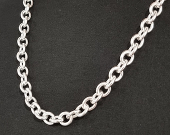 May include: A silver chain necklace with large, round links.