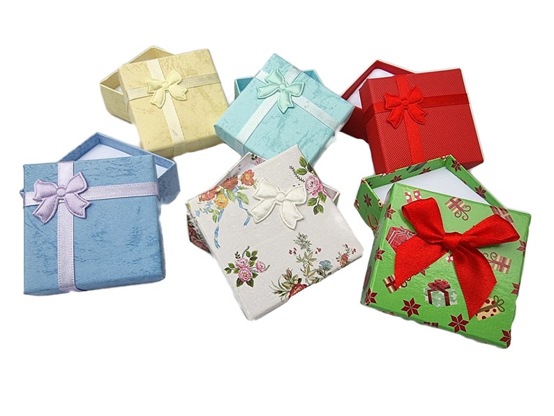 May include: Six small gift boxes with different patterns and colors. The boxes are made of cardboard and have a satin ribbon bow on top. The boxes are perfect for small gifts or jewelry.