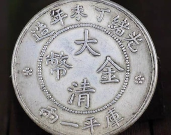 Könnte beinhalten: Eine chinesische Silbermünze mit den Schriftzeichen "大清銀幣" (Da Qing Yin Bi) und "光緒年造" (Guangxu Nian Zao) auf der Vorderseite. Die Münze ist von einem Perlenrand umgeben.