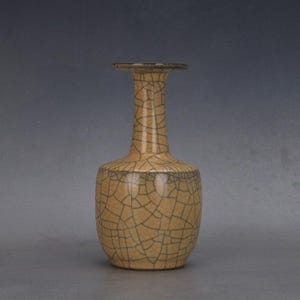 Może przedstawiać: Biały ceramiczny kubek z czarnym uchwytem i napisem "But First, Coffee" czarną, pogrubioną czcionką. Kubek stoi na białej powierzchni.