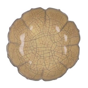 Może przedstawiać: Jasnożółta ceramiczna miska z pękniętą glazurą i falistym brzegiem. Miska ma unikalną, organiczną fakturę.