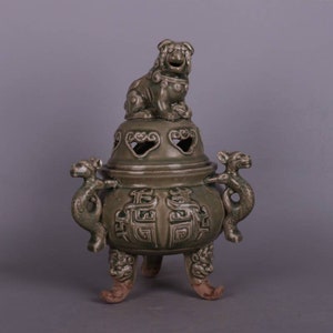 Peut inclure: Un brûle-encens en céramique verte avec un motif de dragon et trois pieds. Un petit lion en céramique verte est assis sur le dessus du couvercle.