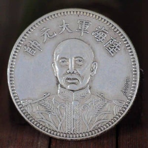 以下が含まれることがあります： 軍服を着た男性の肖像画が描かれた銀貨。コインには「中華民国陸軍」と「Koshsh」という中国語の文字が刻まれている。