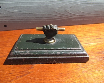 Pisapapeles victoriano de c. 1800. Bronce y hierro fundido. Puño cerrado sosteniendo un pergamino.