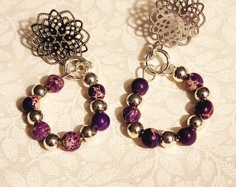 25) Small mottled purple stones alternating with silvery beads made into a circle, with an ornate filigree silvery post.  Eye-catching!