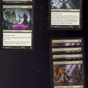May include: A collection of Magic: The Gathering cards featuring dark fantasy artwork. The cards include "Curse of Death's Hold", "Curse of Misfortunes", and "Curse of Thirst". The cards are black with white text and illustrations.