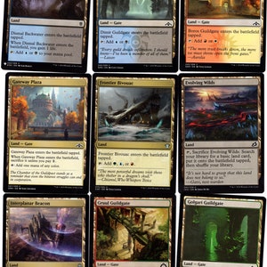 May include: A set of ten Magic: The Gathering cards featuring different lands, each with a unique illustration and ability. The cards are from the Guildgate cycle, which features lands that produce two colors of mana.
