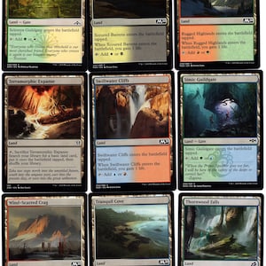 May include: A set of ten Magic: The Gathering cards featuring various land types, including Selesnya Guildgate, Scoured Barrens, Rugged Highlands, Terramorphic Expanse, Swiftwater Cliffs, Simic Guildgate, Wind-Scarred Crag, Tranquil Cove, and Thornwood Falls. Each card features a unique illustration and text describing its abilities.