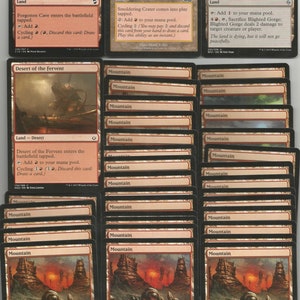 May include: A collection of Magic: The Gathering cards featuring various lands, including Forgotten Cave, Smoldering Crater, Blighted Gorge, and Desert of the Fervent. The cards are in various shades of brown, red, and green, with illustrations depicting volcanic landscapes, caves, and mountains.