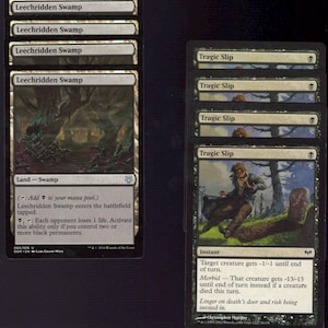 May include: A collection of Magic: The Gathering trading cards. The cards feature swamp and instant spells with dark artwork and text descriptions. The cards are black and white with green accents.
