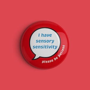 May include: Red button with a white speech bubble that says "I have sensory sensitivity" and "please be patient" around the bottom edge.