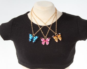May include: Three gold chain necklaces with butterfly pendants. The butterflies are blue, pink and orange.