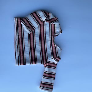 May include: A white, pink, and black striped long-sleeve shirt.